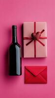 Romantic gift arrangement with red envelopes, wine bottle, and hearts on pink background photo