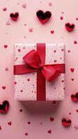 Colorful gift box adorned with red ribbon and hearts on pink background for special occasions photo