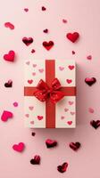 Colorful gift box adorned with red ribbon and hearts on pink background for special occasions photo