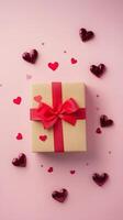 Colorful gift box adorned with red ribbon and hearts on pink background for special occasions photo
