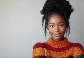 Young woman in cozy sweater smiles while working on laptop at home photo