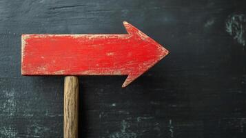 Empty red wooden sign on a dark textured surface ready for messages or directions photo
