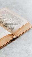 Old open book resting on a wooden surface with soft lighting and natural textures photo
