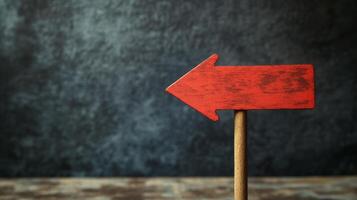 Empty red wooden sign on a dark textured surface ready for messages or directions photo