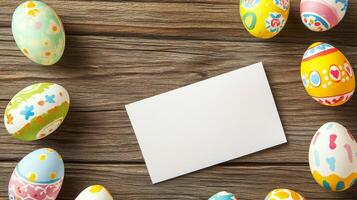 Colorful Easter eggs arranged around a blank card on a wooden surface for festive celebration photo