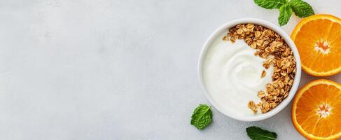 Healthy breakfast bowl with yogurt, granola, and fresh oranges on a light background photo