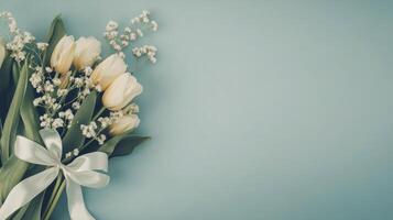 Beautiful bouquet of tulips and babys breath on soft blue background with ribbon photo