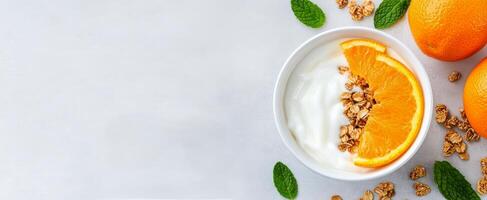 Healthy breakfast bowl with yogurt, granola, and fresh oranges on a light background photo