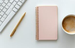 Workspace setup featuring a notepad, coffee cup, and keyboard for creative tasks photo