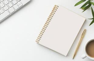 Workspace setup featuring a notepad, coffee cup, and keyboard for creative tasks photo