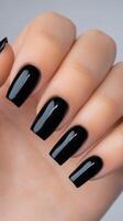 Elegant black nail polish on well manicured hand showcasing stylish design and finish photo