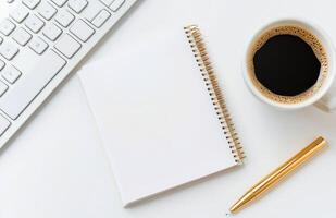 Workspace setup featuring a notepad, coffee cup, and keyboard for creative tasks photo