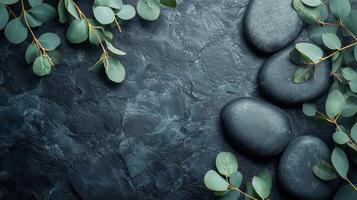 Spa stones and eucalyptus leaves on a black background photo
