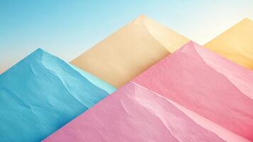 Colorful paper mountains on a blue sky background photo