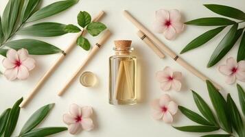 Essential oil bottle with flowers and bamboo sticks on white background photo