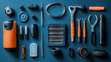 A variety of tools and accessories laid out on a blue surface photo