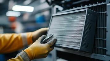 A person in yellow gloves is holding a piece of metal photo