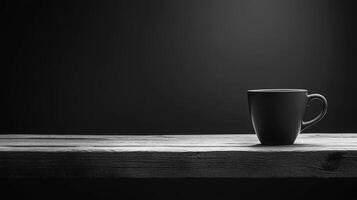 Black and white photo of a coffee cup on a wooden table