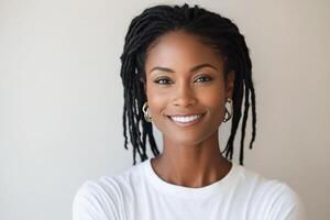 Portrait of a woman with long dreadlocks smiling against a light background photo