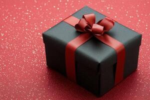 Elegant black gift box with red ribbon on vibrant red background photo