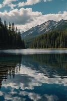 A serene lake surrounded by mountains and forests, reflecting clouds in the water. photo