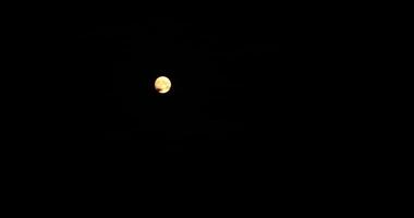 Full moon at night with cloud real time. Mystery moon on dark sky background with copy space for Halloween. Moving from focus into blur bokeh. Halloween spooky background video