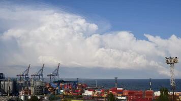 Time lapse of white clouds forming and moving fast over maritime port landscape in harbour of European Black sea coast. Silhouettes of raised crane jibs of container loading bridges of cargo terminal video