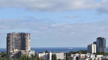 Urban skyline time lapse with multistory buildings and floating clouds over sea shore. Cityscape in Europe with blue sea water on horizon video