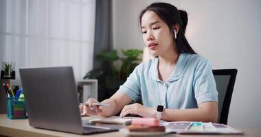 Handheld selective focus shot, Female freelancer wear wireless headphones explaining project in online meeting with team members via laptop in home office. Working from home, Remote working. video