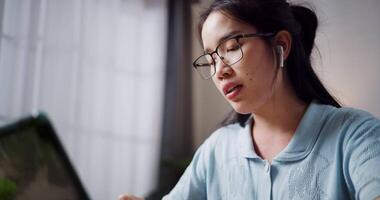 Footage of handheld, Relaxed female freelancer having snack during conference with team members via digital tablet in home office. Work from home, remote working. video