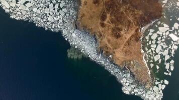 Drone view vertically down of a rocky cape surrounded by a high rocky shore video