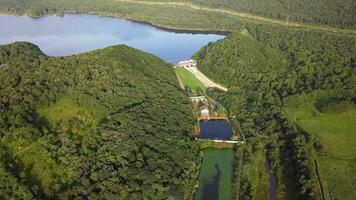 Drone view of smooth water and a dam surrounded by green hills video