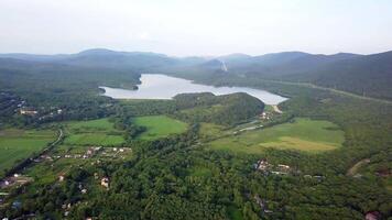 Drone view of smooth water and a dam surrounded by green hills video