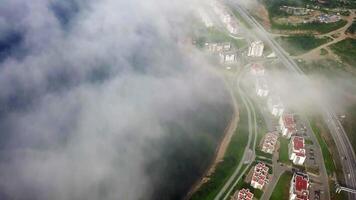 Drone view of the city by the sea. Part of the buildings is covered with fog. video