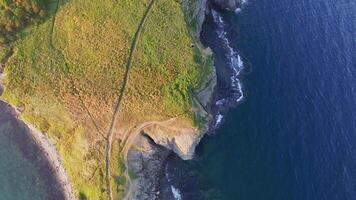 Aerial. Captivating aerial view of rocky cape with sheer cliffs and beaches at sunset video