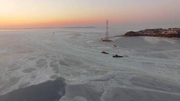 Drone view of the ice-bound strait with two tugboats operating at sunset video