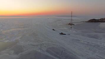 Drone view of the ice-bound strait with tugboats operating at sunset video