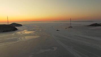 Drone view of the ice-bound strait with tugboats operating at sunset video