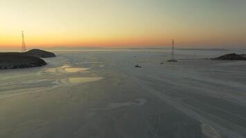 Drone view of the ice-bound strait with tugboats operating at sunset video