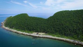 Drone view above the sea along the rocky coast on a sunny day. video