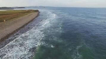 zumbido ver de el mar costa con rocoso apuntalar y olas video