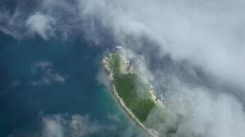 View from drone flying above the rocky cape wooded shrouded in fog video