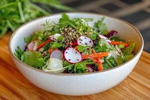 Fresh colorful salad with various vegetables and herbs placed on wooden surface photo