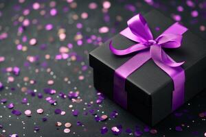 Purple bow on black gift box with glittering confetti scattered on dark surface photo