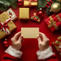 Holiday spirit shines with gifts and a blank card held by festive hands in a cozy setting photo