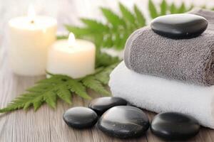 Relaxing spa setup with towels, stones, candles, and greenery for a calming atmosphere photo