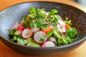 Fresh colorful salad with various vegetables and herbs placed on wooden surface photo