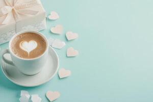 A cup of coffee with a heart design in the foam sits on a small plate photo