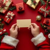 Holiday spirit shines with gifts and a blank card held by festive hands in a cozy setting photo