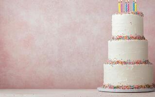 Elegant three tier cake with colorful sprinkles and candles for a celebration photo